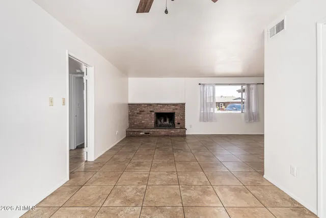 an empty room with windows and fireplace