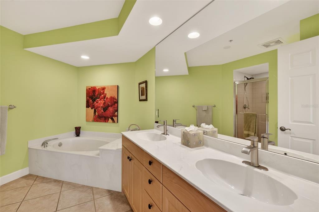 3191 Matecumbe Key Road, Unit 202 Punta Gorda, FL 33955 - Photo 22 of 37 a bathroom with a double vanity sink a mirror and a bathtub