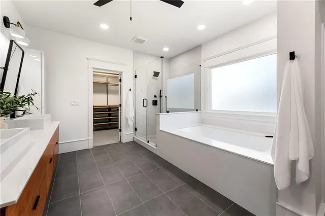 a spacious bathroom with a tub shower and sink