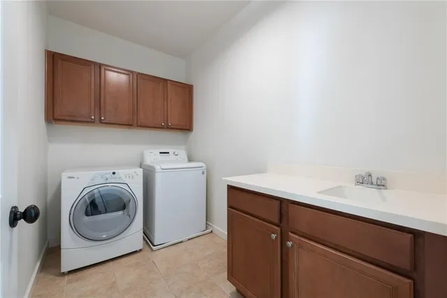 a utility room with sink dryer and washer