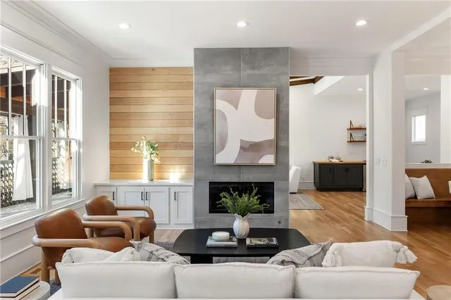 a living room with furniture fireplace and a large window