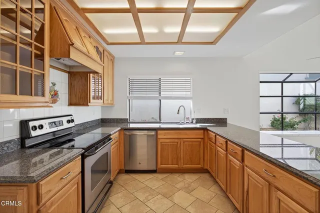 a kitchen with stainless steel appliances granite countertop a sink and a stove