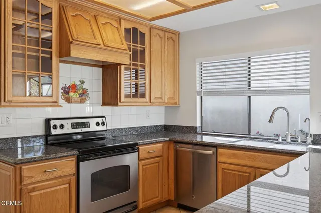 a kitchen with stainless steel appliances granite countertop a sink and a stove