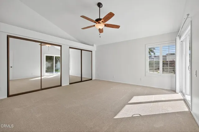 a view of an empty room with a ceiling fan and window