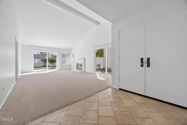 a view of an empty room with window and cabinet
