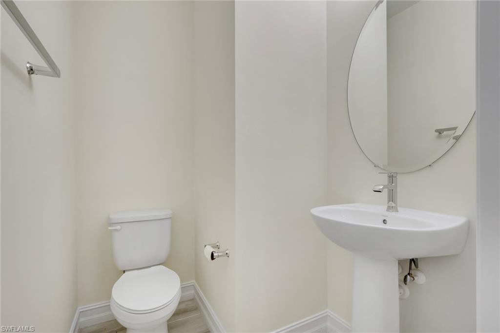 7540 Carnegie Way Naples, FL 34119 - Photo 20 of 40 a bathroom with a sink a toilet and mirror