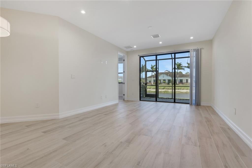 7540 Carnegie Way Naples, FL 34119 - Photo 28 of 40 a view of an empty room with wooden floor and a window