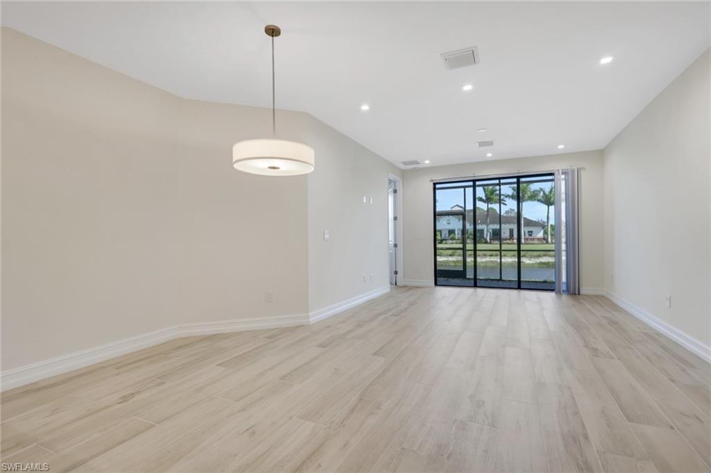 7540 Carnegie Way Naples, FL 34119 - Photo 29 of 40 a view of an empty room with wooden floor and a window