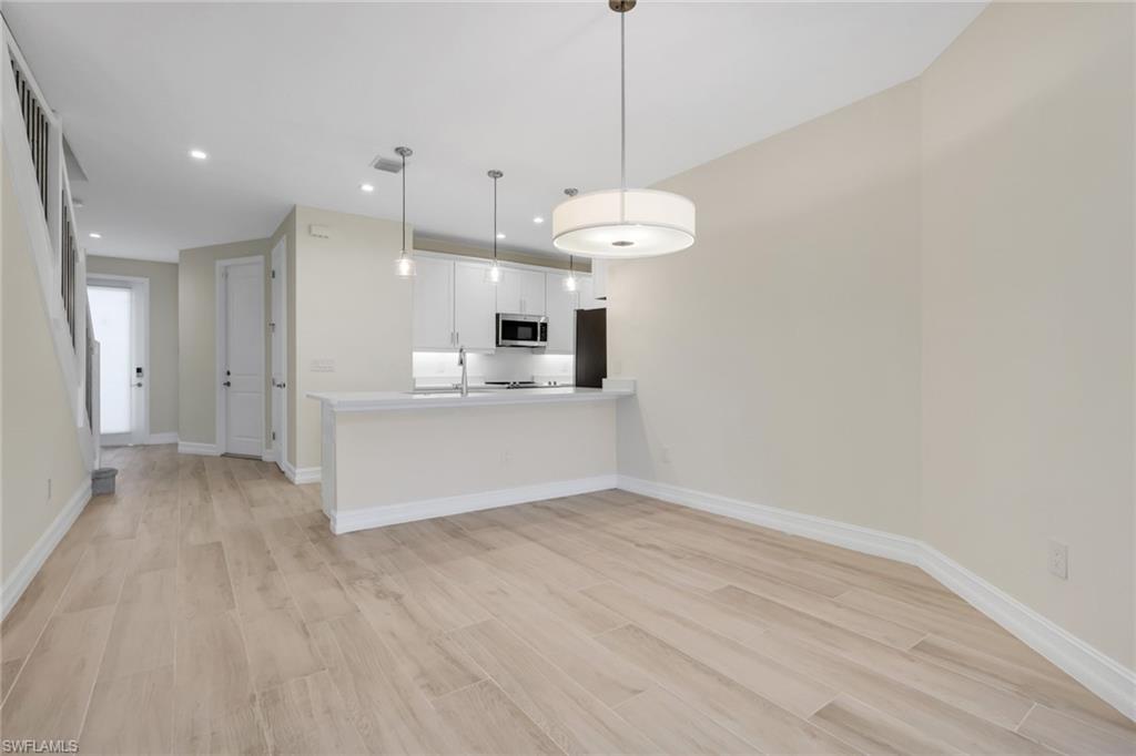 7540 Carnegie Way Naples, FL 34119 - Photo 32 of 40 a view of a kitchen with a dishwasher and a wooden floor
