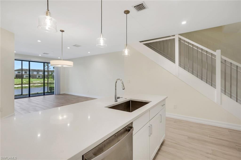 7540 Carnegie Way Naples, FL 34119 - Photo 34 of 40 a view of a kitchen and a sink wooden floor windows and a ceiling fan