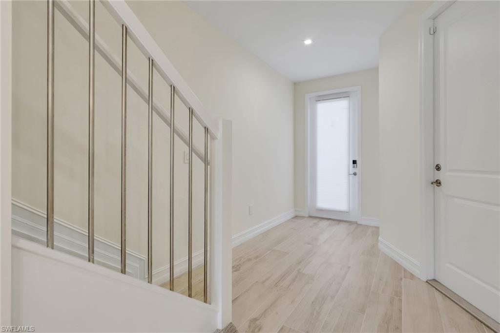 7540 Carnegie Way Naples, FL 34119 - Photo 40 of 40 a view of a hallway with wooden floor