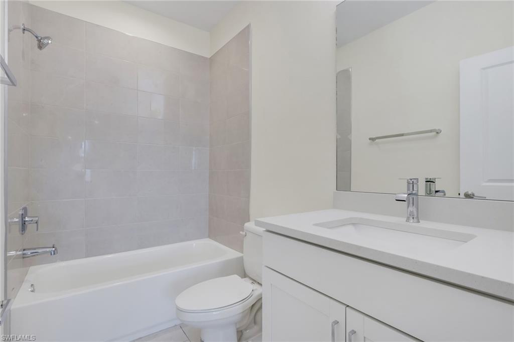 7540 Carnegie Way Naples, FL 34119 - Photo 9 of 40 a bathroom with a sink toilet and a bathtub