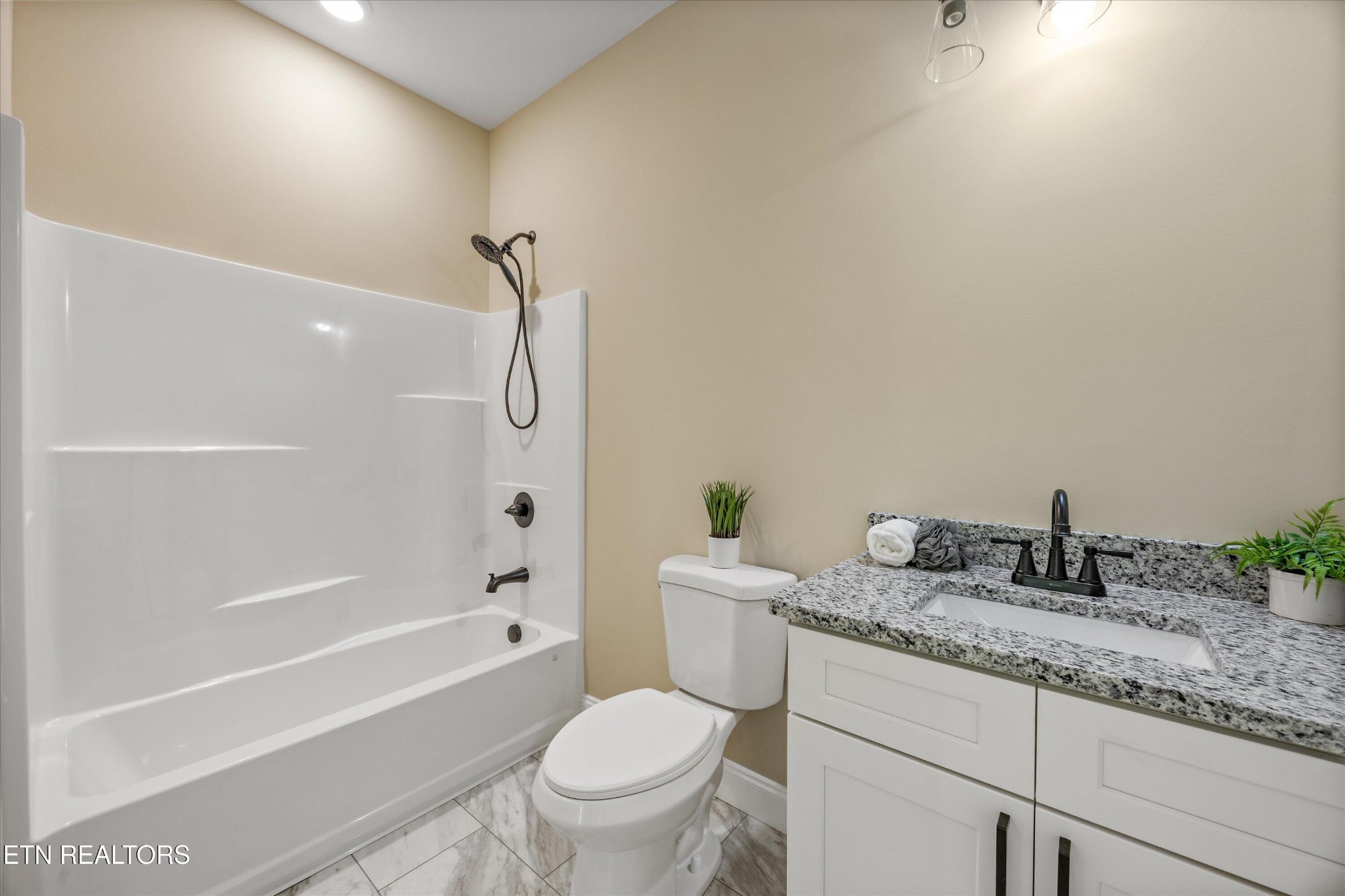210 Daniel Morris Point Clinton, TN 37716 - Photo 19 of 45 a bathroom with a granite countertop toilet a sink and a bathtub