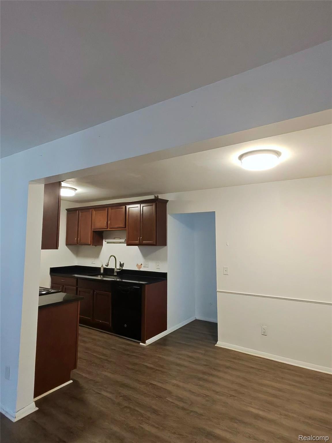 25301 Five Mile Road, Unit 130 Redford, MI 48239 - Photo 6 of 15 Open concept living area featuring wood-finish flooring, white walls with decorative chair rail molding, and flush-mount ceiling lighting