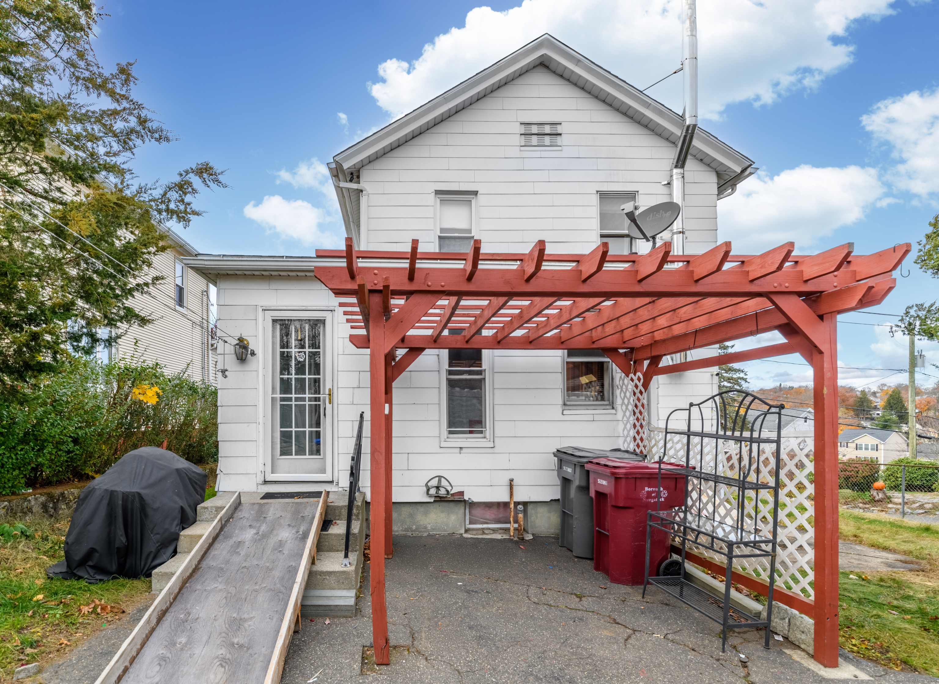 22 Lewis Street Naugatuck, CT 06770 - Photo 3 of 31 a view of a patio with table and chairs with wooden fence and plants