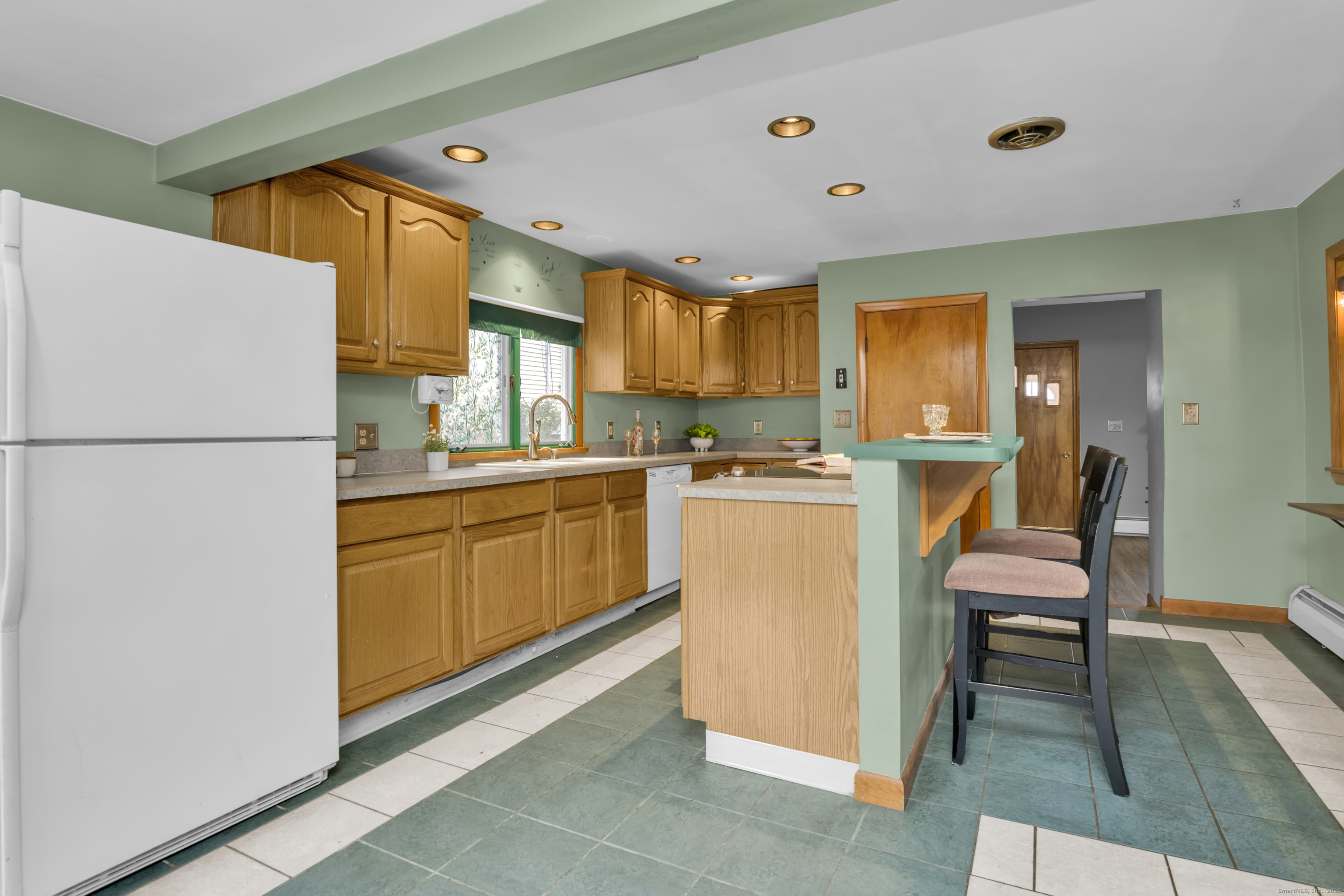 22 Lewis Street Naugatuck, CT 06770 - Photo 7 of 31 a kitchen with a refrigerator a sink dishwasher with a dining table and chairs