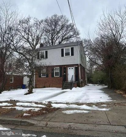 a front view of a house with a yard covered in snow