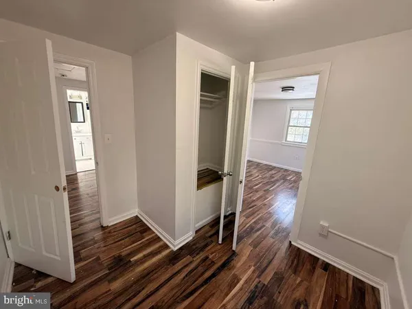 a view of a hallway with wooden floor and stairs