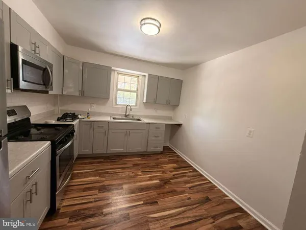 a kitchen with a sink stove top oven and cabinets