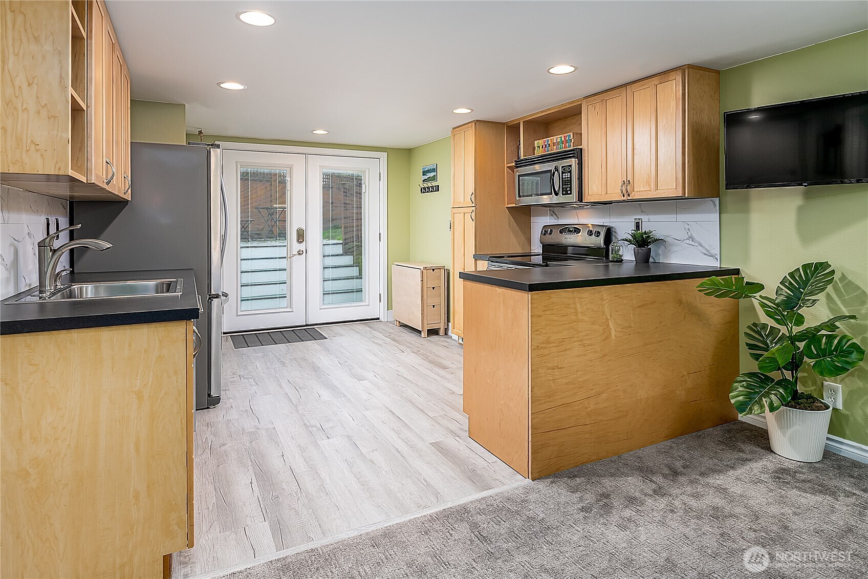 7638 Winona Avenue North, Unit B Seattle, WA 98103 - Photo 16 of 20 a kitchen with granite countertop a refrigerator and a stove top oven