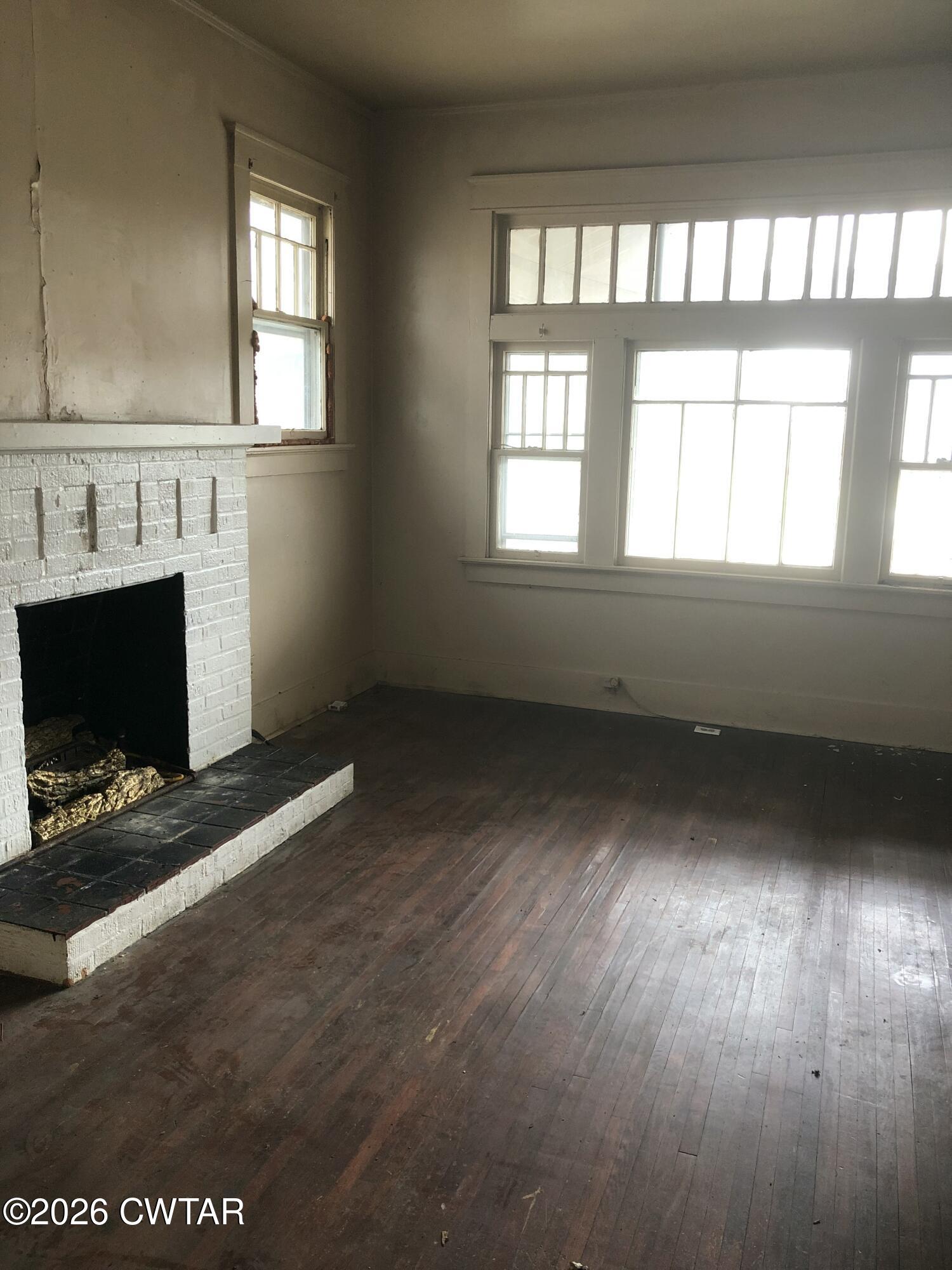 126 McCorry Street Jackson, TN 38301 - Photo 5 of 8 a view of an empty room with wooden floor and a window