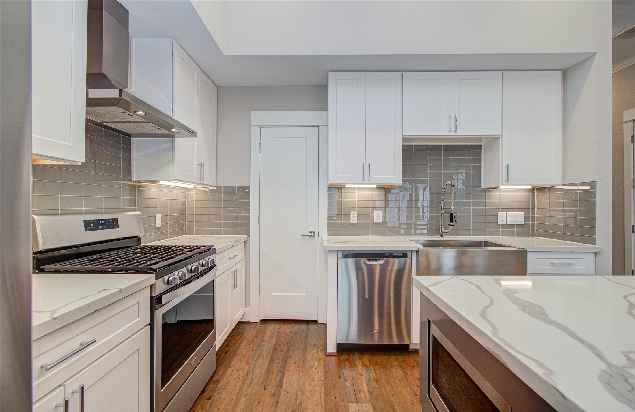 3516 Bastrop Street Houston, TX 77004 - Photo 7 of 25 a kitchen with white cabinets stainless steel appliances and wooden floor