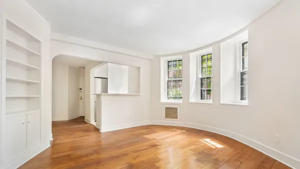 an empty room with windows and closet
