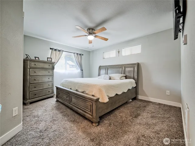 a bedroom with a bed and ceiling fan
