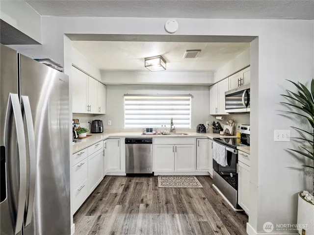 a kitchen with stainless steel appliances a refrigerator sink and stove