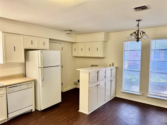 a kitchen with white cabinets and white appliances