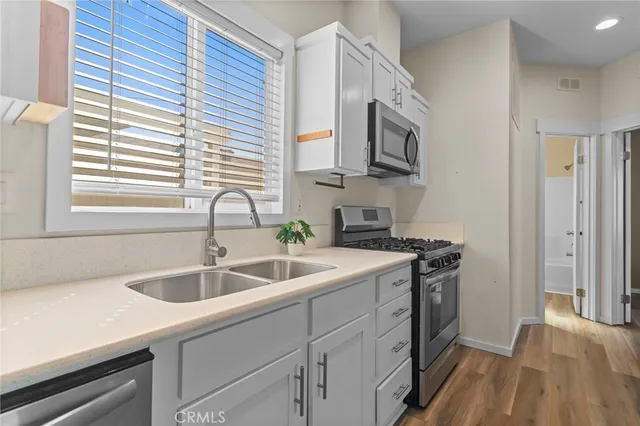 a kitchen with stainless steel appliances granite countertop a sink and a stove