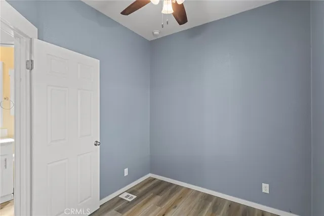 a view of a room with a ceiling fan and wooden floor