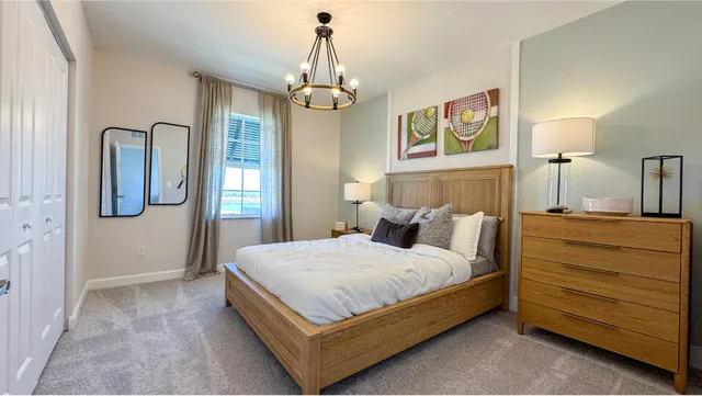 a bedroom with a bed chandelier and a window