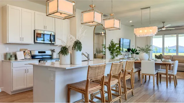 a kitchen with stainless steel appliances granite countertop a stove top oven a dining table and chairs with wooden floor