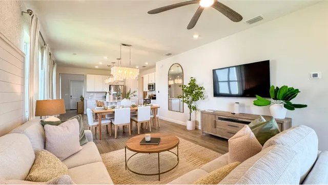a living room with furniture potted plant and a large window