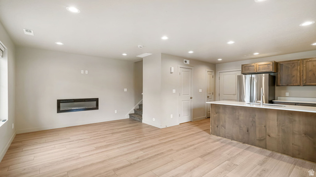 1223 East 1775 North Payson, UT 84651 - Photo 22 of 45 Open-concept living space featuring wood-finish flooring, recessed lighting, and a built-in electric fireplace
