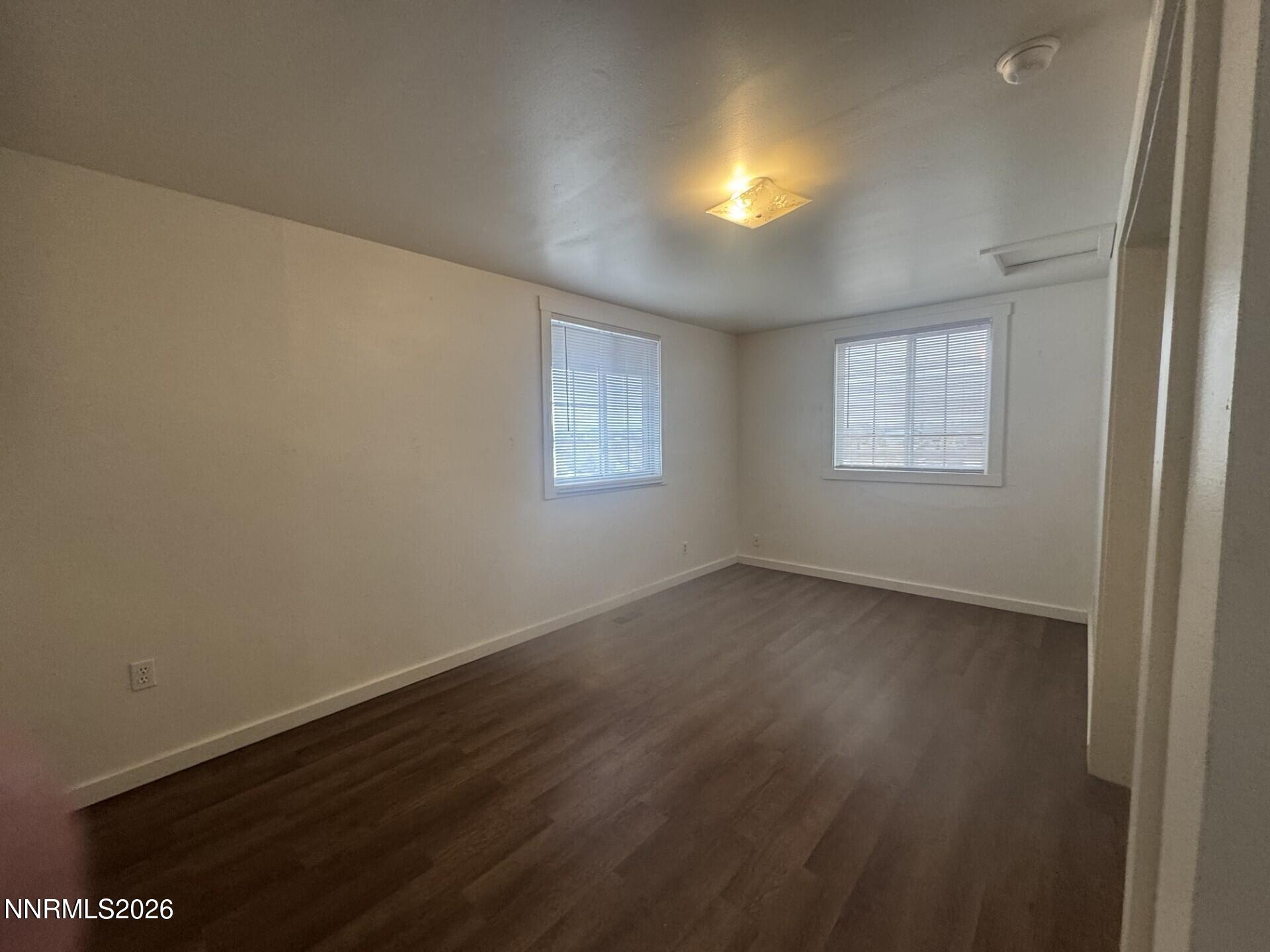 7533 Sandhill Road Fallon, NV 89406 - Photo 8 of 19 an empty room with wooden floor and windows