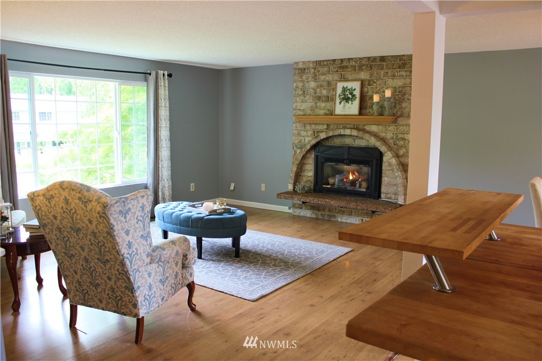 709 222nd Street Southwest Bothell, WA 98021 - Photo 4 of 38 a living room with furniture a table and a fireplace