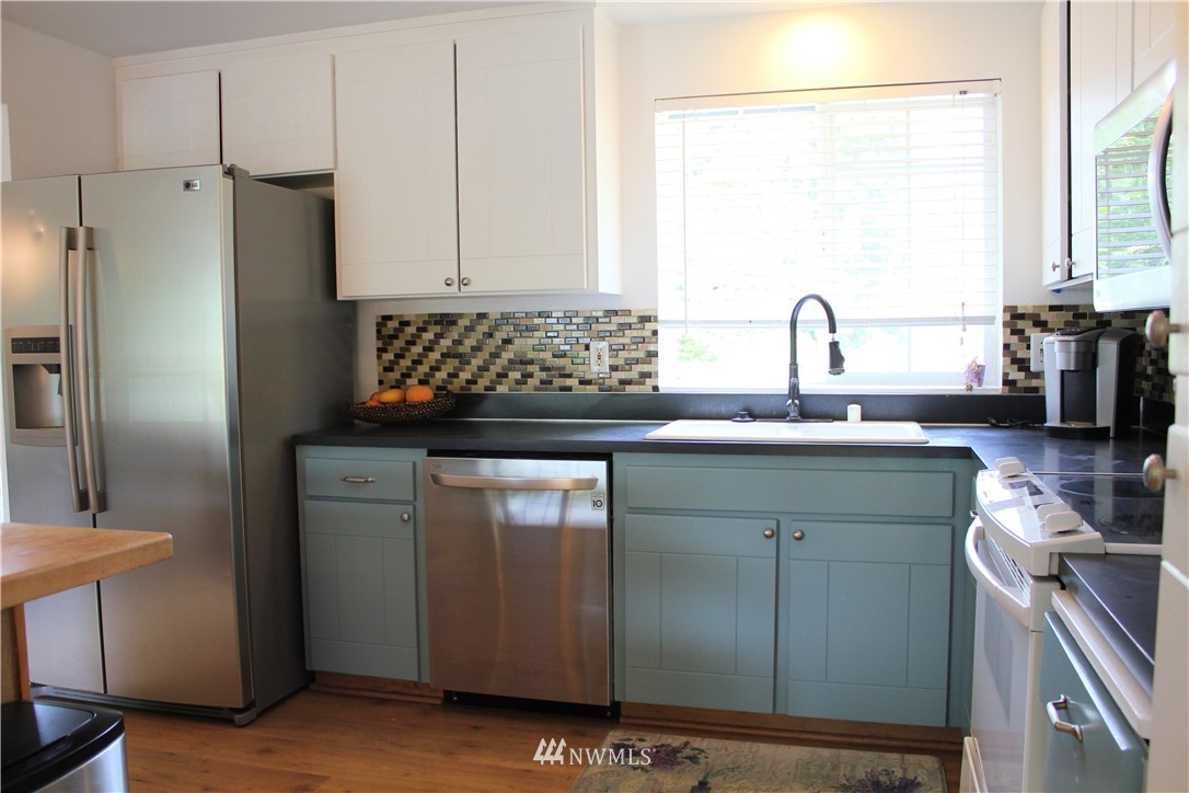 709 222nd Street Southwest Bothell, WA 98021 - Photo 6 of 38 a kitchen with stainless steel appliances granite countertop a refrigerator and a sink