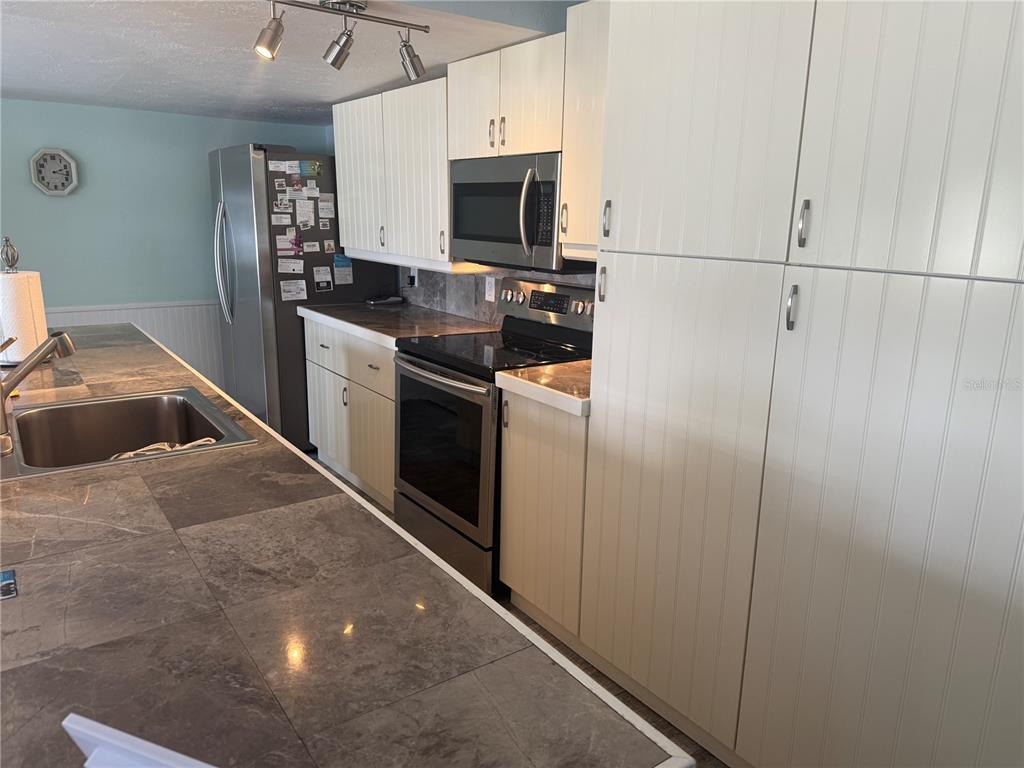 6190 Daffodil Road Venice, FL 34293 - Photo 5 of 22 a kitchen with stainless steel appliances granite countertop a refrigerator a stove and a sink