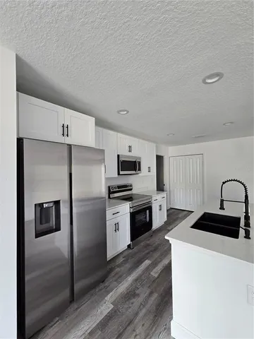 a kitchen with a refrigerator stove and sink