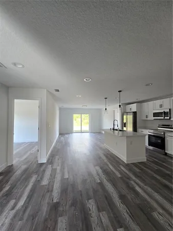 a view of kitchen and hall with wooden floor