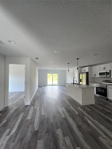 a view of kitchen and hall with wooden floor