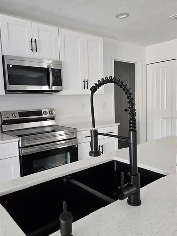 a kitchen with a sink and white cabinets