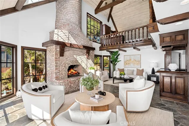 a living room with furniture a fireplace and a chandelier