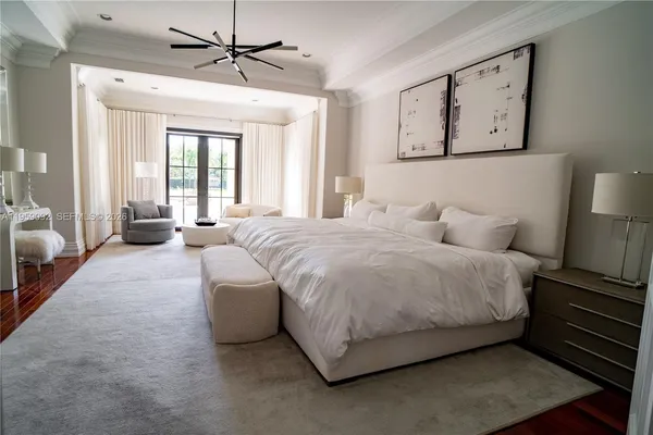 a spacious bedroom with a bed a couch and a chandelier