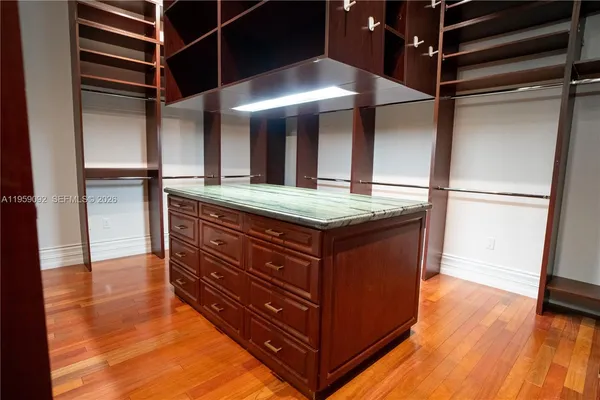 a room with a refrigerator and wooden floor