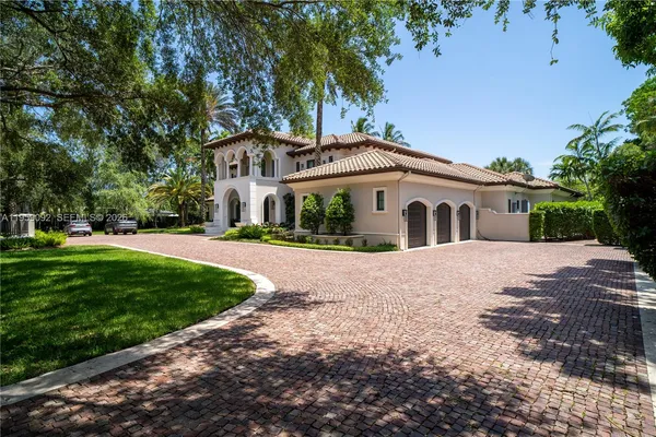 a white house with a large tree in front of it