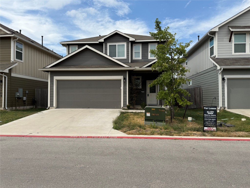 12110 Corsicana Trail, Unit 19B Manor, TX 78653 - Photo 22 of 23 View of front of house featuring driveway, a shingled roof, and an attached garage
