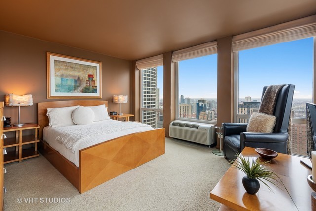 111 East Chestnut Street, Unit 43A Chicago, IL 60611 - Photo 3 of 16 a spacious bedroom with a bed and a couch next to a window
